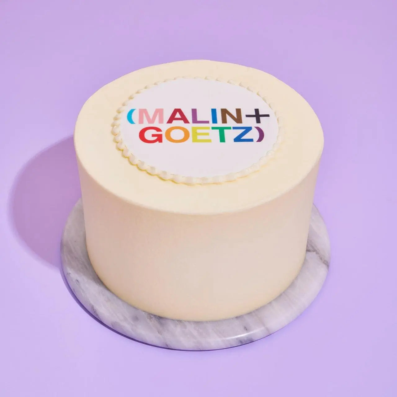 White iced cake with logo - Crumbs & Doilies